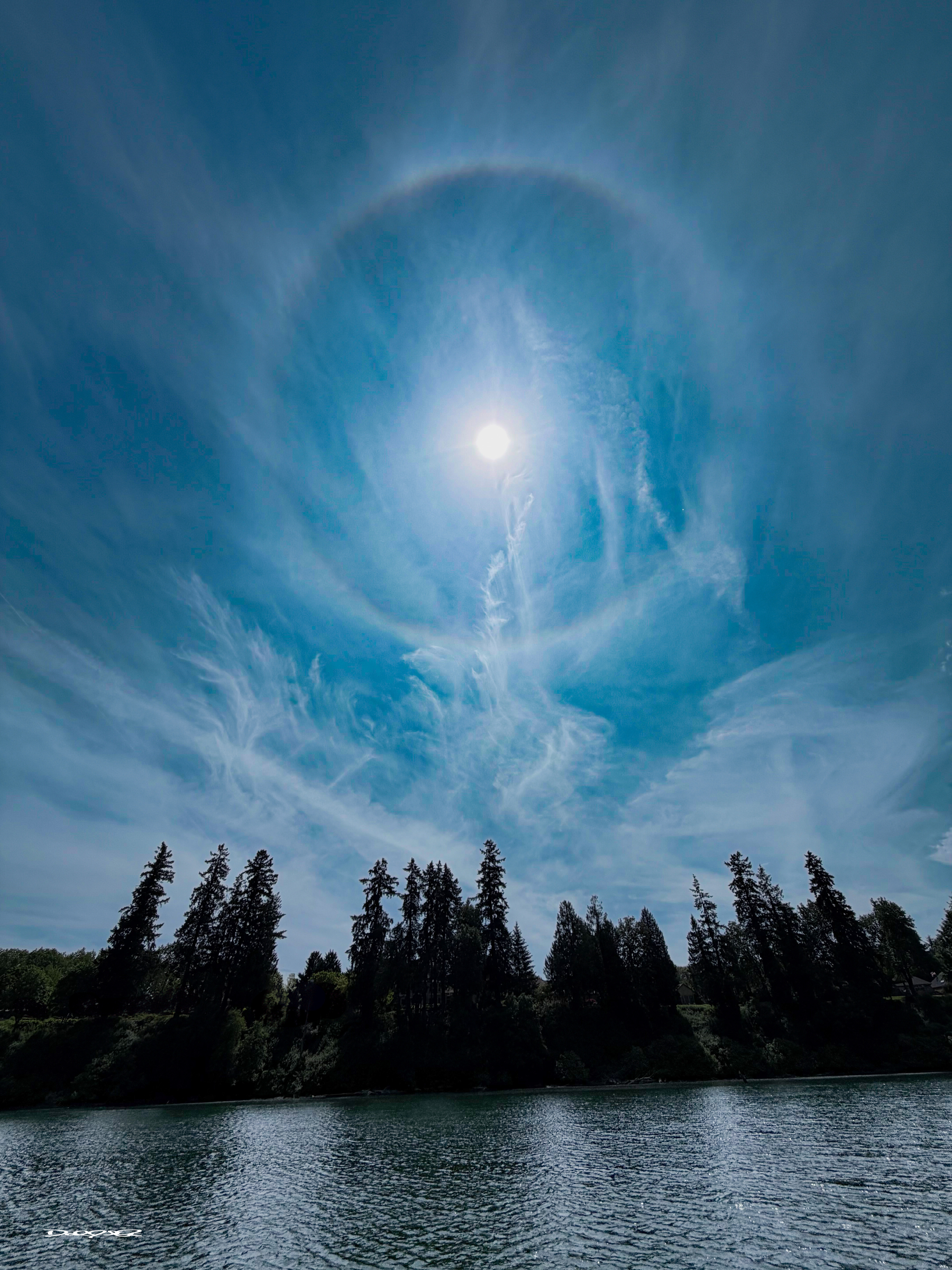 A sun halo (or 22° halo) is a bright, white, or occasionally colored ring appearing around the Sun, caused by sunlight refracting through, or reflecting off, millions of tiny hexagonal ice crystals suspended in high-altitude cirrus or cirrostratus clouds. They often indicate incoming moisture and weather changes.
